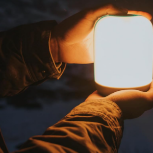 a person holding a glowing lantern